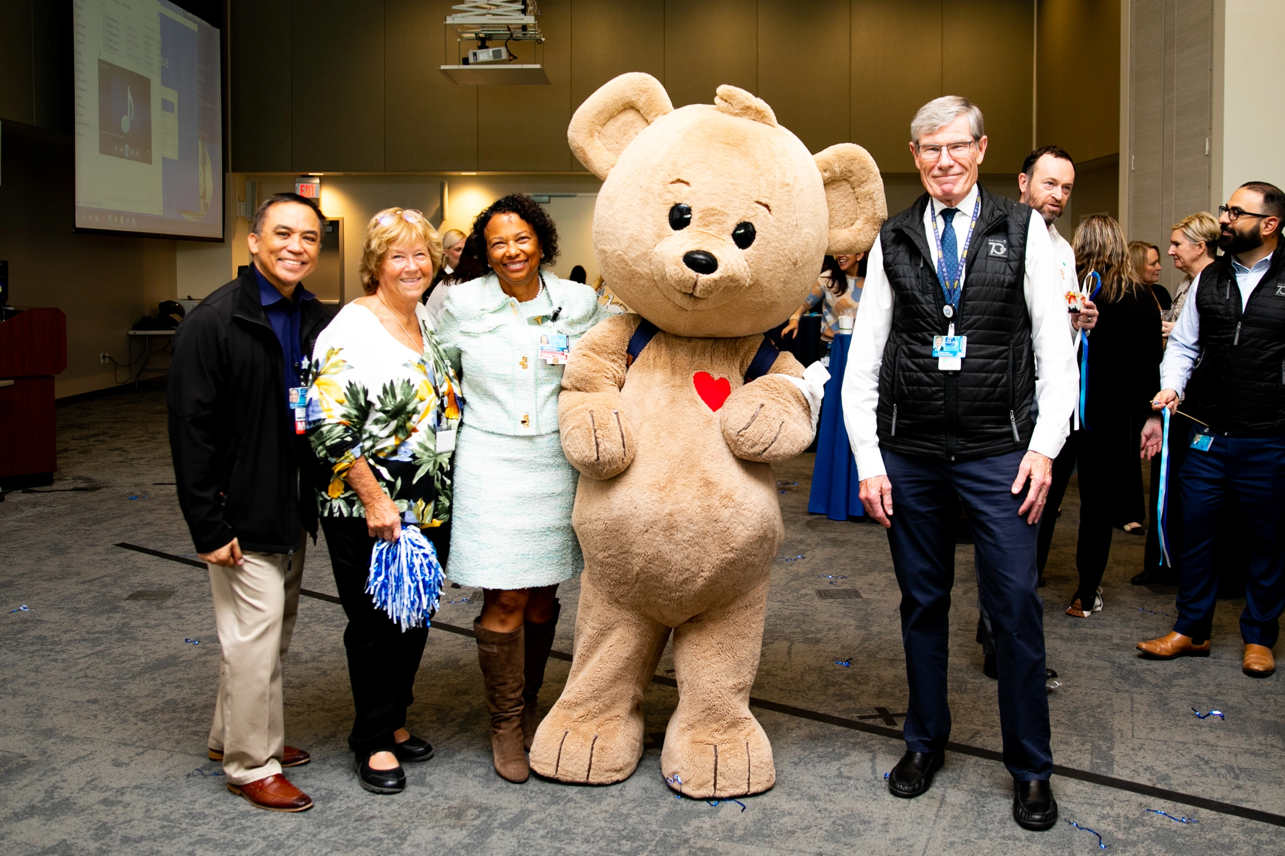 Rady Children's Hospital San Diego executives pose with the new CHOCO The Bear mascot.